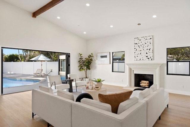 living room with beamed ceiling, light wood-type flooring, and high vaulted ceiling