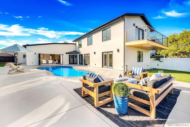 back of property with a fenced in pool, an outdoor living space, a balcony, and a patio