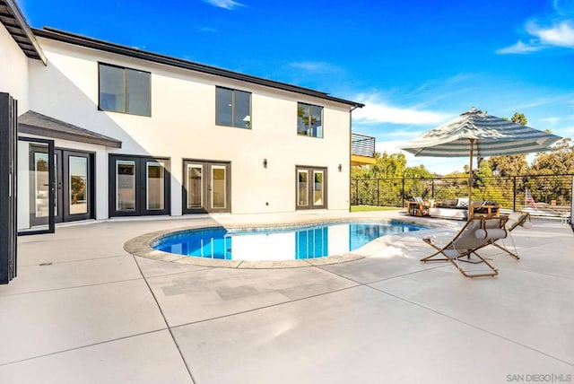 view of swimming pool featuring french doors and a patio