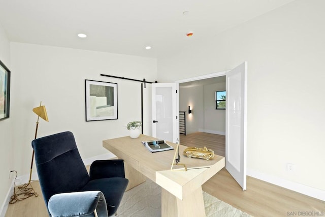 office featuring a barn door and light wood-type flooring