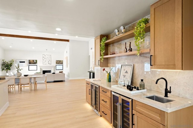 kitchen with sink, beverage cooler, and light hardwood / wood-style floors