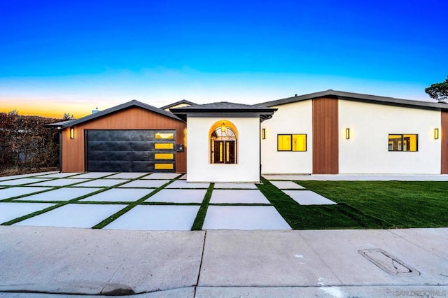 view of front of home with a yard and a garage