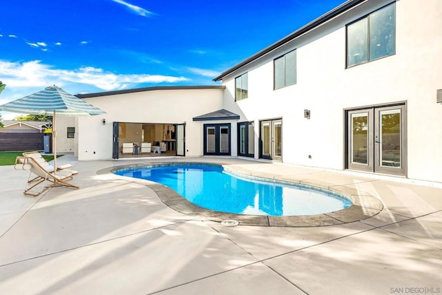 view of pool with french doors and a patio area