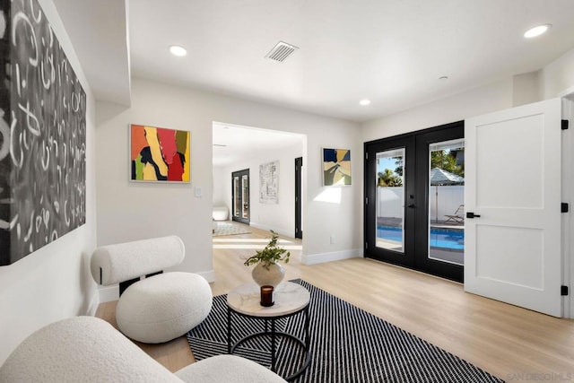 living room with french doors and light hardwood / wood-style flooring