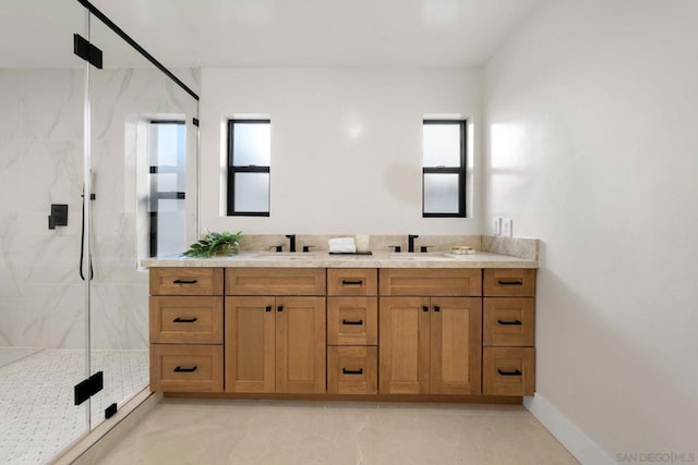 bathroom with a wealth of natural light, vanity, and a shower with shower door