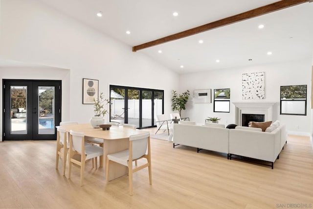 dining space featuring light hardwood / wood-style floors, high vaulted ceiling, and french doors