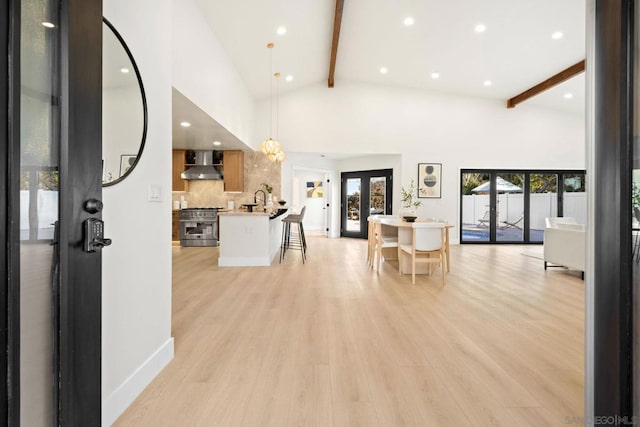 interior space featuring sink, french doors, beamed ceiling, high vaulted ceiling, and light wood-type flooring