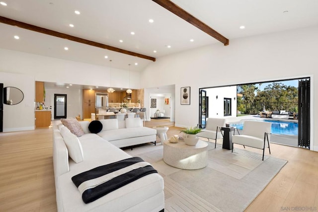 living room featuring beamed ceiling, light wood-type flooring, and high vaulted ceiling