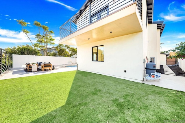 rear view of property with a yard, a balcony, and a patio area