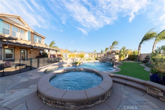 view of swimming pool with an in ground hot tub, pool water feature, and a patio area