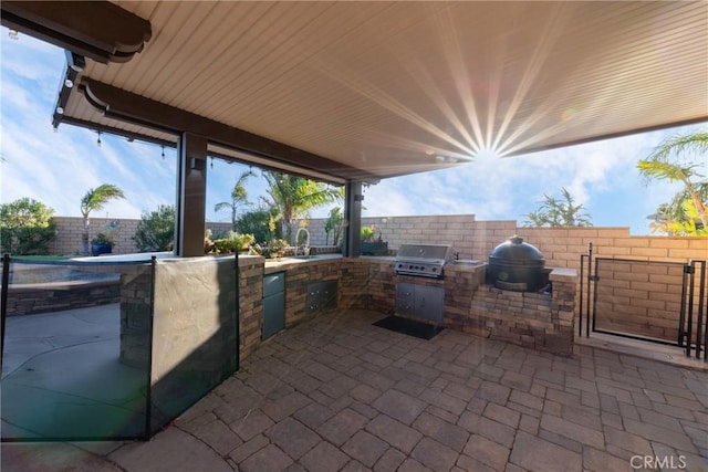 view of patio / terrace with a grill, sink, and exterior kitchen