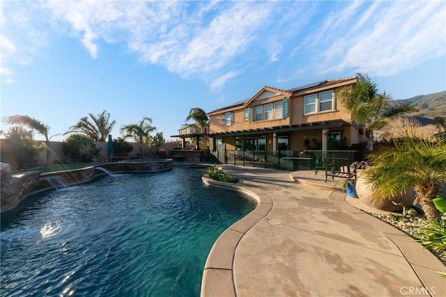 view of swimming pool with pool water feature, an in ground hot tub, and a patio