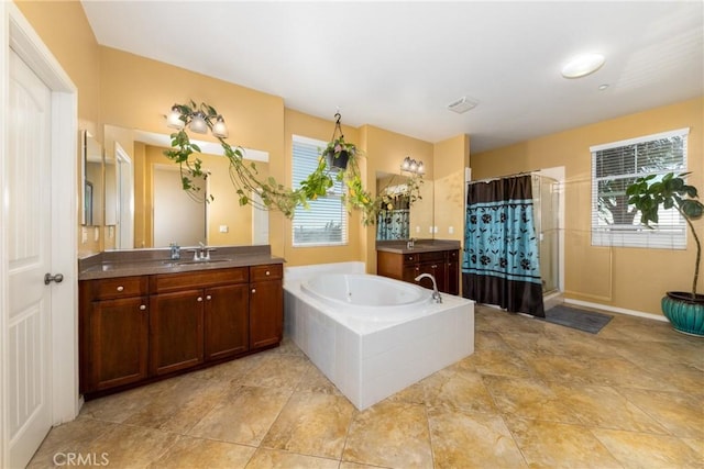 bathroom with vanity, a healthy amount of sunlight, and shower with separate bathtub