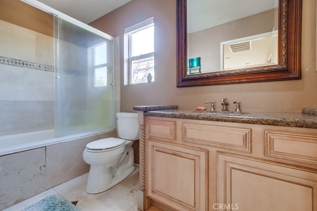 full bathroom featuring toilet, tile patterned flooring, tiled shower / bath, and vanity