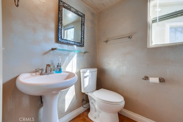 bathroom featuring plenty of natural light, tile patterned floors, and toilet