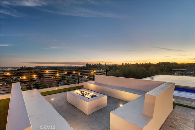 patio terrace at dusk featuring an outdoor fire pit