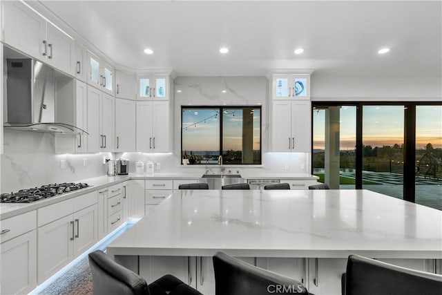 kitchen featuring white cabinetry, stainless steel gas stovetop, a breakfast bar, and a kitchen island