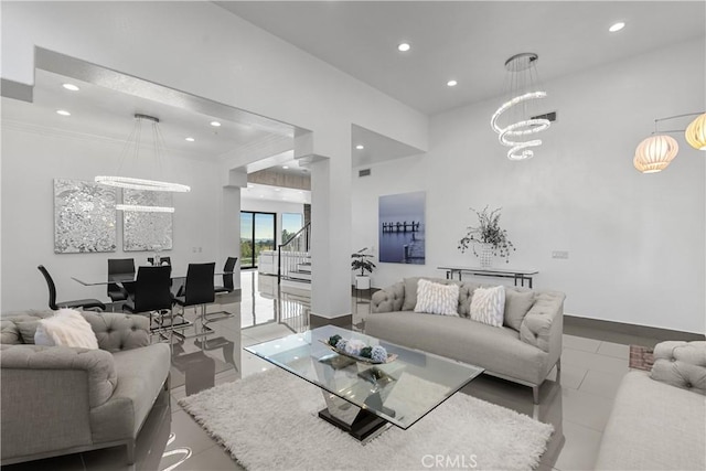 living room with ornamental molding, light tile patterned floors, and a notable chandelier