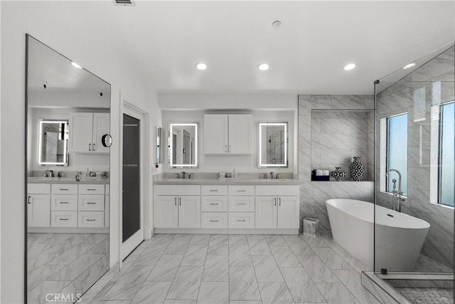 bathroom with vanity, separate shower and tub, and tile walls