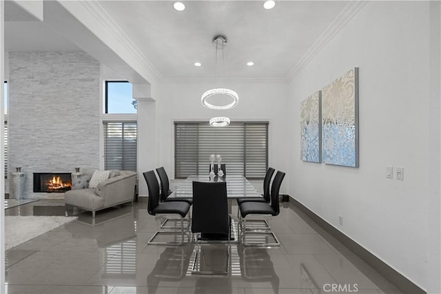 dining space featuring crown molding, tile patterned floors, and a fireplace