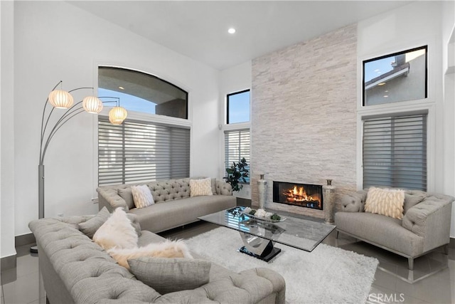 tiled living area with recessed lighting and a stone fireplace