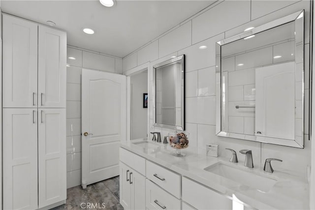 bathroom featuring hardwood / wood-style floors, vanity, tile walls, and decorative backsplash