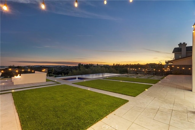 yard at dusk with an in ground hot tub