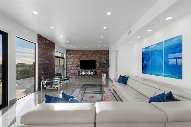 living room featuring a glass covered fireplace, visible vents, and recessed lighting