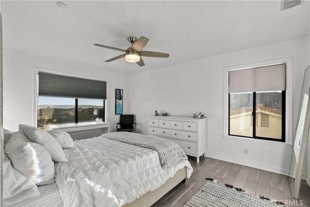 bedroom featuring light wood-style floors, baseboards, visible vents, and ceiling fan