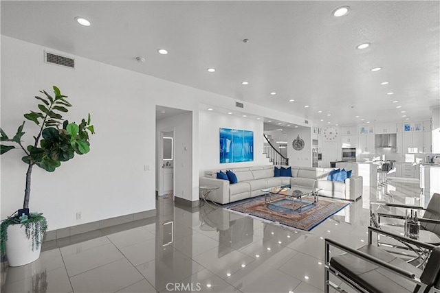 living area with light tile patterned floors, baseboards, visible vents, and recessed lighting