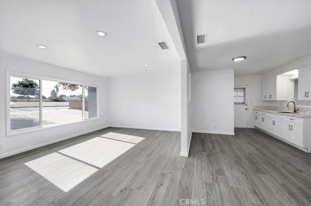 unfurnished living room featuring dark hardwood / wood-style floors and sink