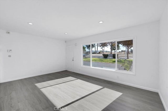 unfurnished room with dark hardwood / wood-style flooring