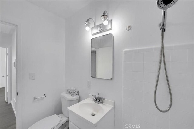 bathroom with hardwood / wood-style floors, vanity, and toilet