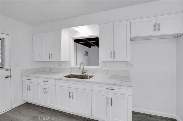 kitchen featuring white cabinetry, sink, light stone countertops, and dark hardwood / wood-style floors