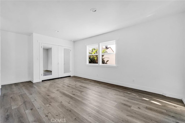 unfurnished bedroom with wood-type flooring and french doors