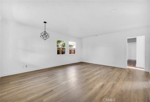 empty room featuring light hardwood / wood-style flooring and crown molding