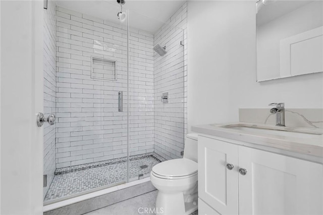 bathroom with tile patterned flooring, vanity, toilet, and walk in shower