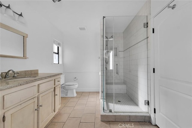 bathroom featuring tile patterned floors, vanity, toilet, and walk in shower