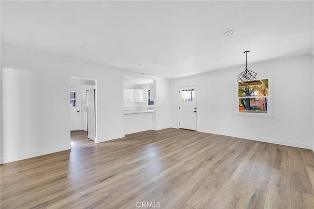 unfurnished living room with light hardwood / wood-style floors and crown molding