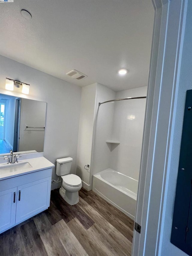 full bathroom with hardwood / wood-style flooring, vanity, toilet, and shower / washtub combination