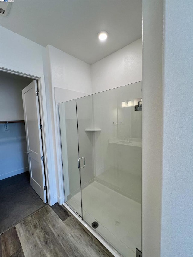 bathroom featuring hardwood / wood-style floors and a shower with shower door