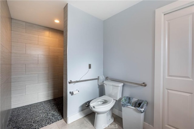 bathroom with toilet, tile patterned flooring, and tiled shower