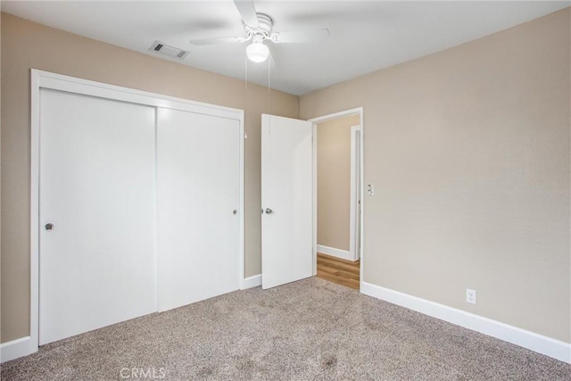 unfurnished bedroom with ceiling fan, carpet floors, and a closet