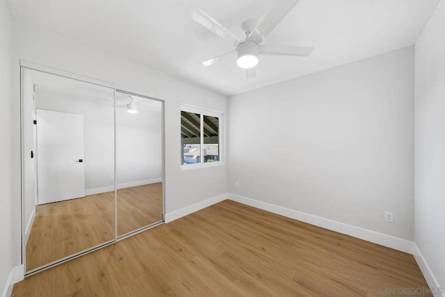 unfurnished bedroom with ceiling fan, a closet, and hardwood / wood-style floors