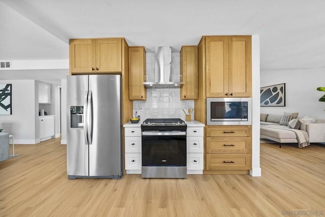 kitchen featuring backsplash, wall chimney exhaust hood, stainless steel appliances, and light hardwood / wood-style floors