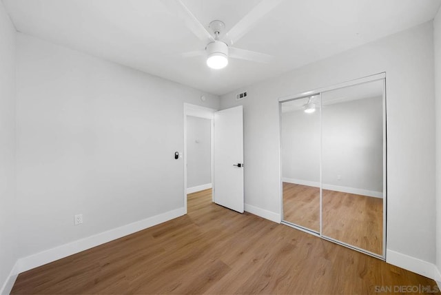 unfurnished bedroom with ceiling fan, a closet, and light hardwood / wood-style flooring