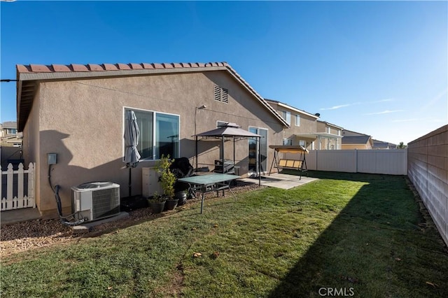 back of property with cooling unit, a yard, and a gazebo