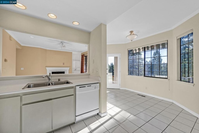 kitchen featuring white dishwasher, crown molding, sink, light tile patterned floors, and white cabinetry