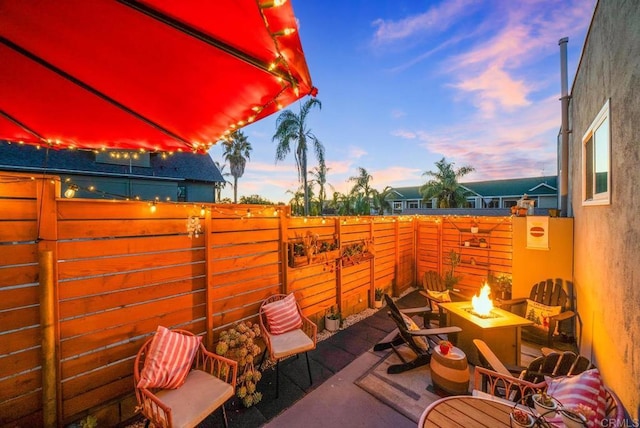 patio terrace at dusk featuring an outdoor fire pit