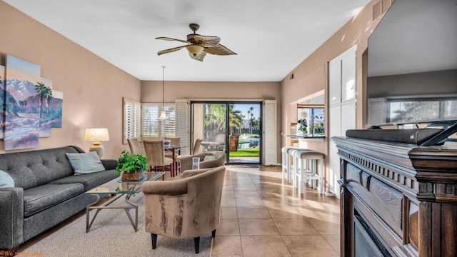 tiled living room featuring ceiling fan and a fireplace